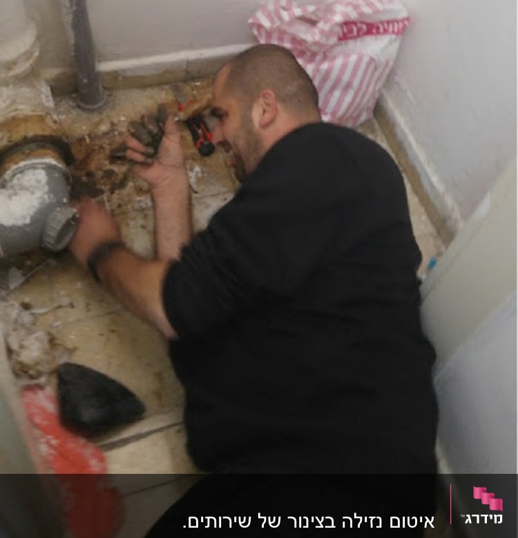 אדם עובד על צינור עם כלי עבודה